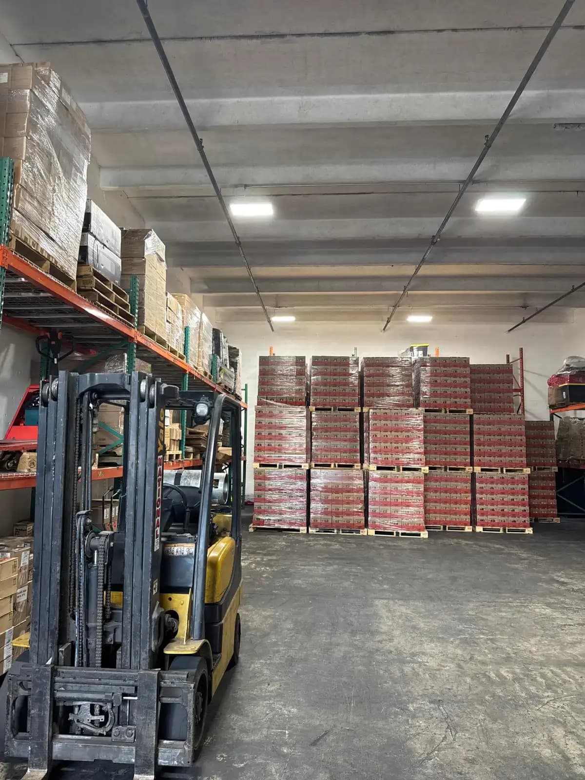 Montacargas e inventario en pallets dentro de bodega en Miami